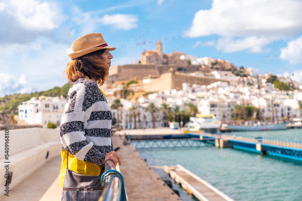 Young woman visiting coastal Ibiza town on vacation from Al Faro, Balearic Islands