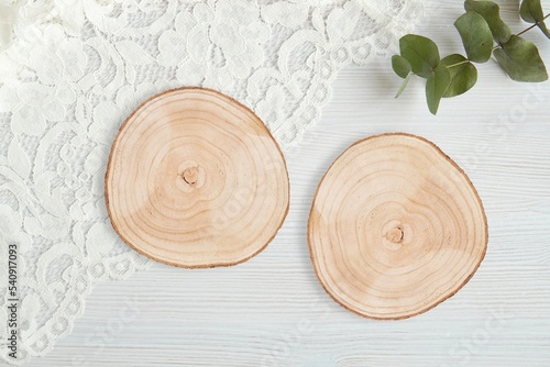Two wood slice coasters mockup for wedding engraving design, wooden table centerpiece, rustic round trays, composition with eucalyptus.