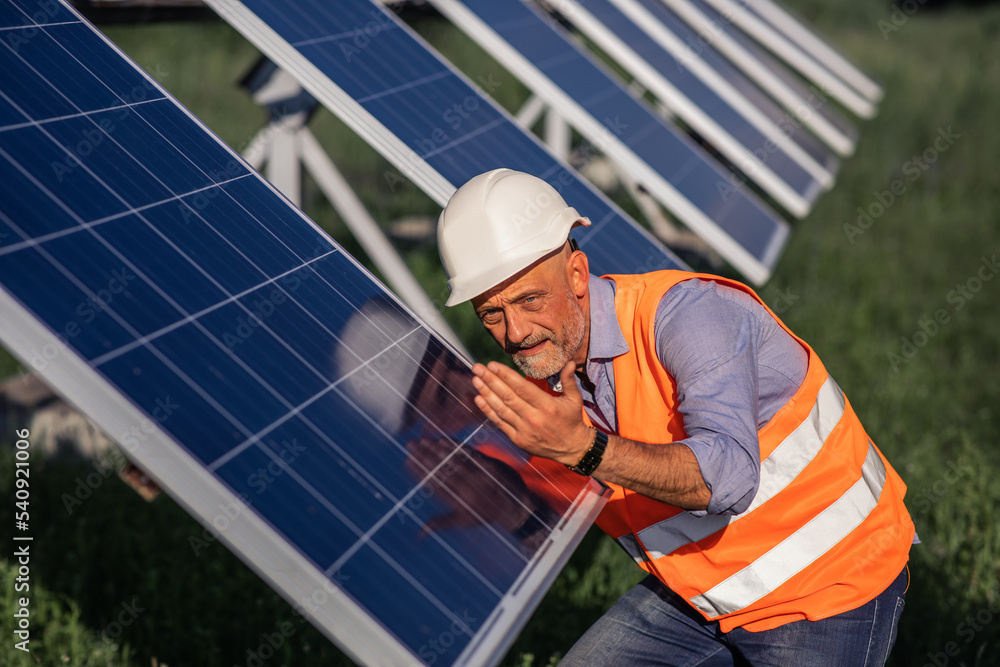 Closeup to the camera at solar power farm station the investor man very charismatic analysing the prices of operation of sun with photovoltaic solar panels Closeup to the camera at solar power farm station the investor man very charismatic analysing the prices of operation of sun with photovoltaic solar panels