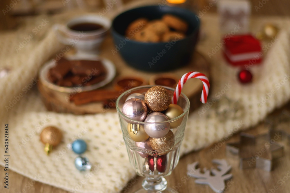 Various Christmas decorations, cup of tea or coffee, sweets, small presents, knitted blanket and candles. Selective focus. Various Christmas decorations, cup of tea or coffee, sweets, small presents, knitted blanket and candles. Selective focus.
