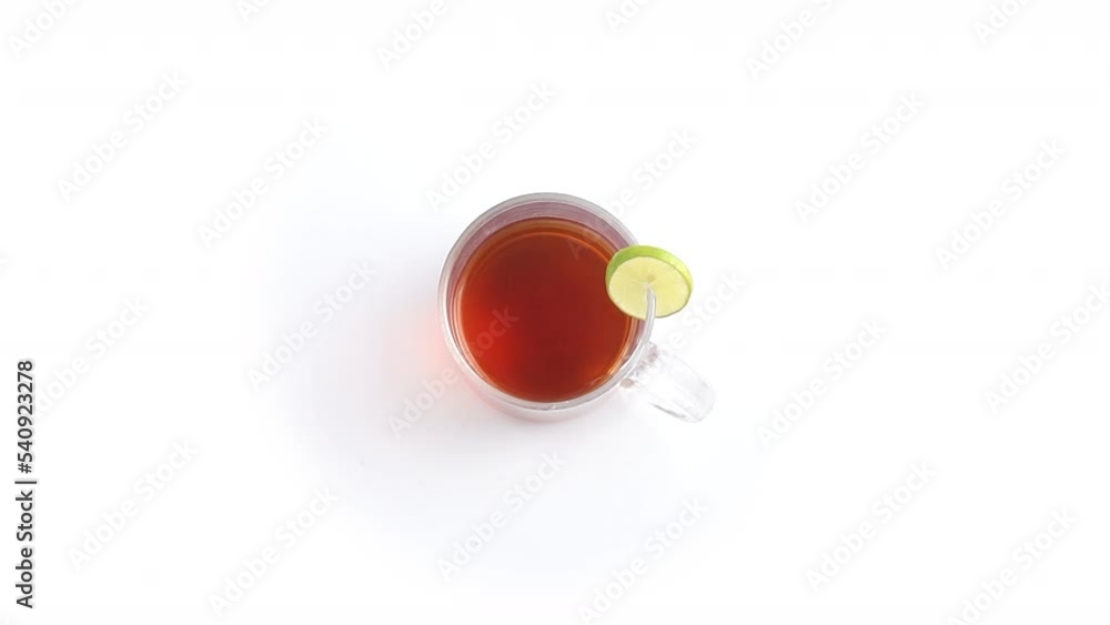 lemon tea in a transparent glass cup with sliced lemon in white background rotating top shot lemon tea in a transparent glass cup with sliced lemon in white background rotating top shot