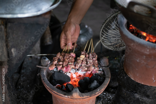 Yogyakarta, Indonesia - September 05 22: Preparing and seasoning of sate klathak. Sate kathak is a unique lamb satay, originally from south of Yogyakarta, Indonesia photo