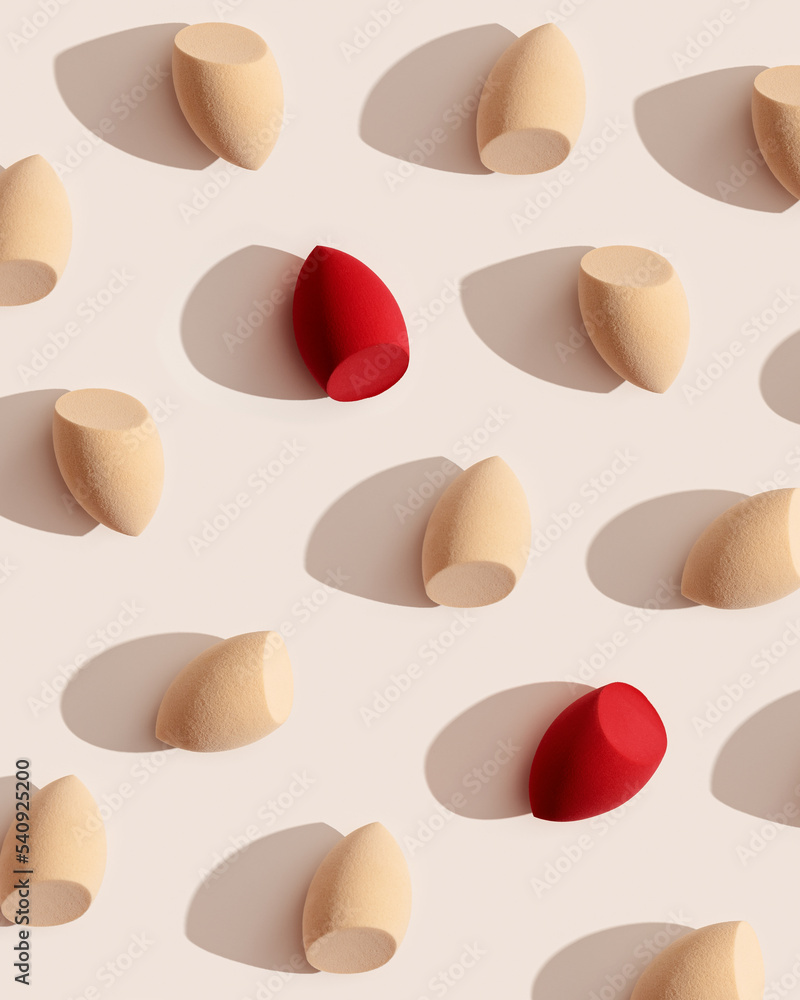 Geometric pattern from makeup sponges for foundation cream on beige background with dark shadows. Beauty blender red and beige. Fashion Flat lay cosmetic sponge, top view graphic layout, Geometric pattern from makeup sponges for foundation cream on beige background with dark shadows. Beauty blender red and beige. Fashion Flat lay cosmetic sponge, top view graphic layout,