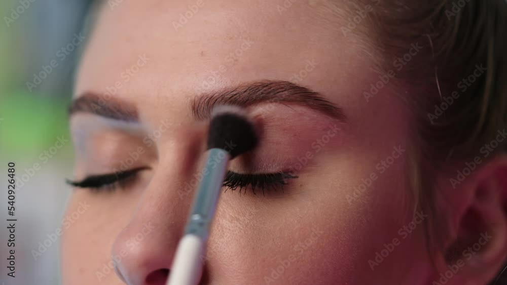 A beautiful girl applies make-up under the eyes close-up. Skin care.