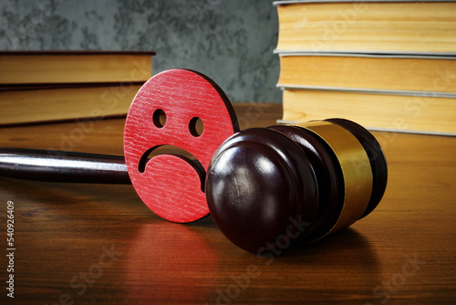 Sad smiley and gavel as concept of anti bullying law. photo