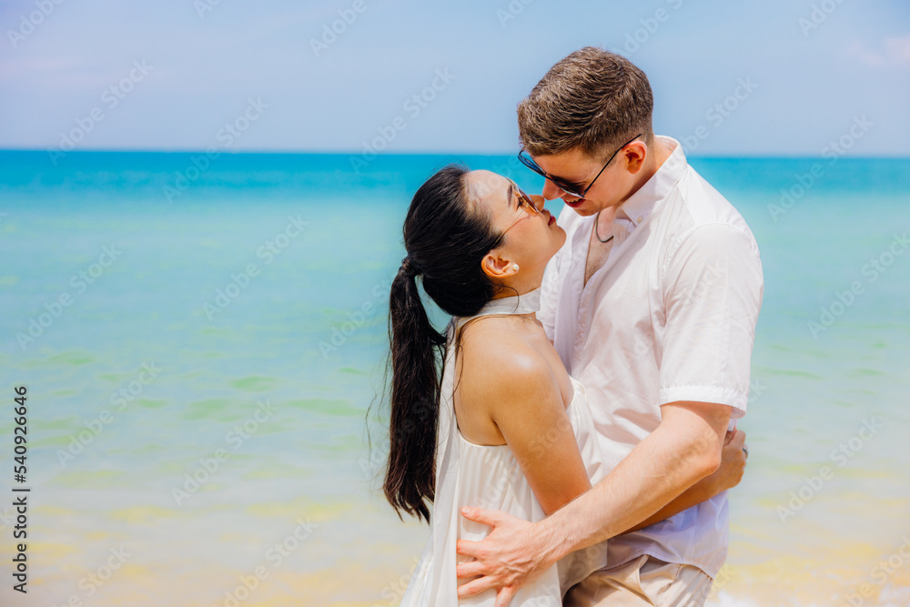 Man and woman couple hugging each other kissing at seaside,Loving young couple standing in each other's arms and kissing on a sandy beach at dusk Man and woman couple hugging each other kissing at seaside,Loving young couple standing in each other's arms and kissing on a sandy beach at dusk
