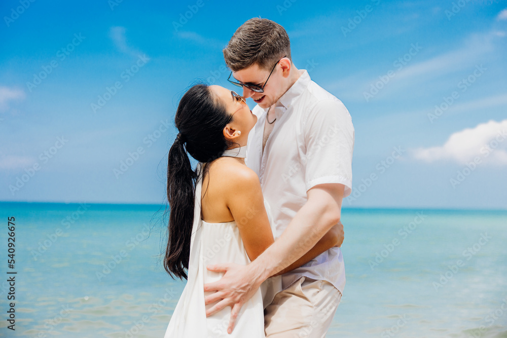 Man and woman couple hugging each other kissing at seaside,Loving young couple standing in each other's arms and kissing on a sandy beach at dusk Man and woman couple hugging each other kissing at seaside,Loving young couple standing in each other's arms and kissing on a sandy beach at dusk