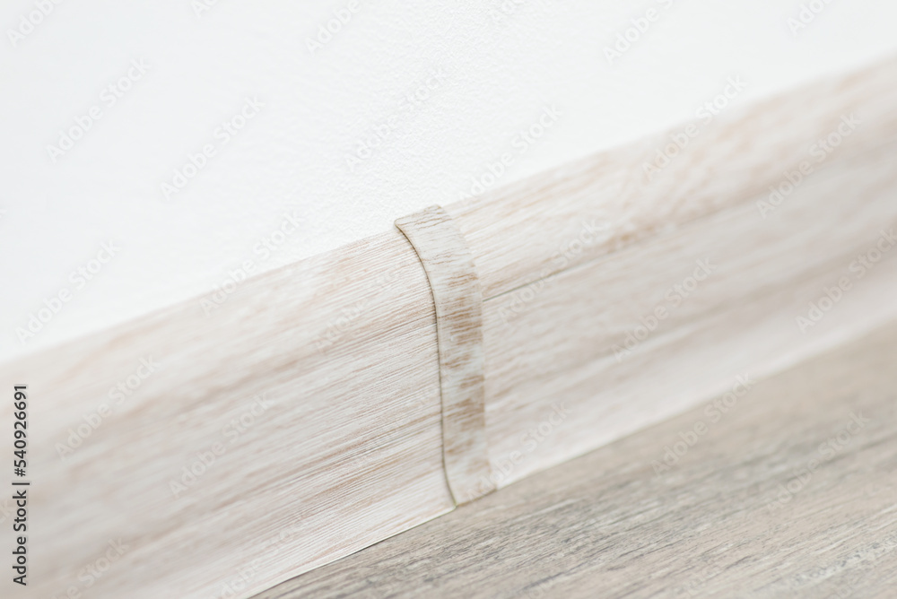 Close up shot of plinth between white wall and linoleum floor