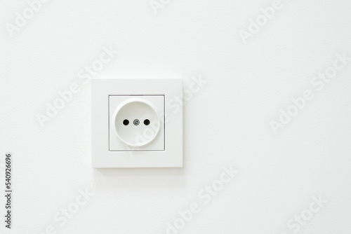 Electric outlet on a white wall. White inked wall with electric socket