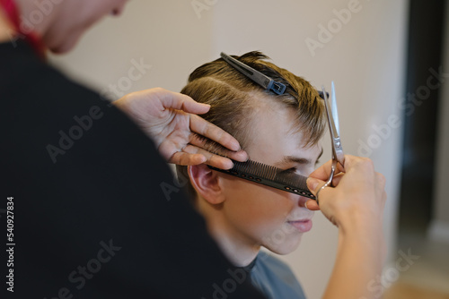 Woman cuts hair of boy at home. Homemade haircut