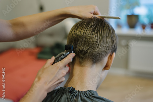 Woman cuts hair of boy at home. Homemade haircut