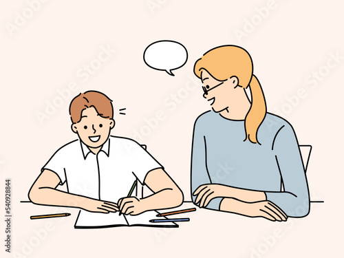 Mother do homework with smiling son 