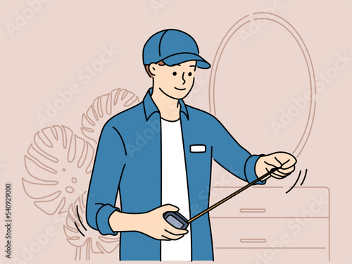 Male mechanic with tape measure work in room