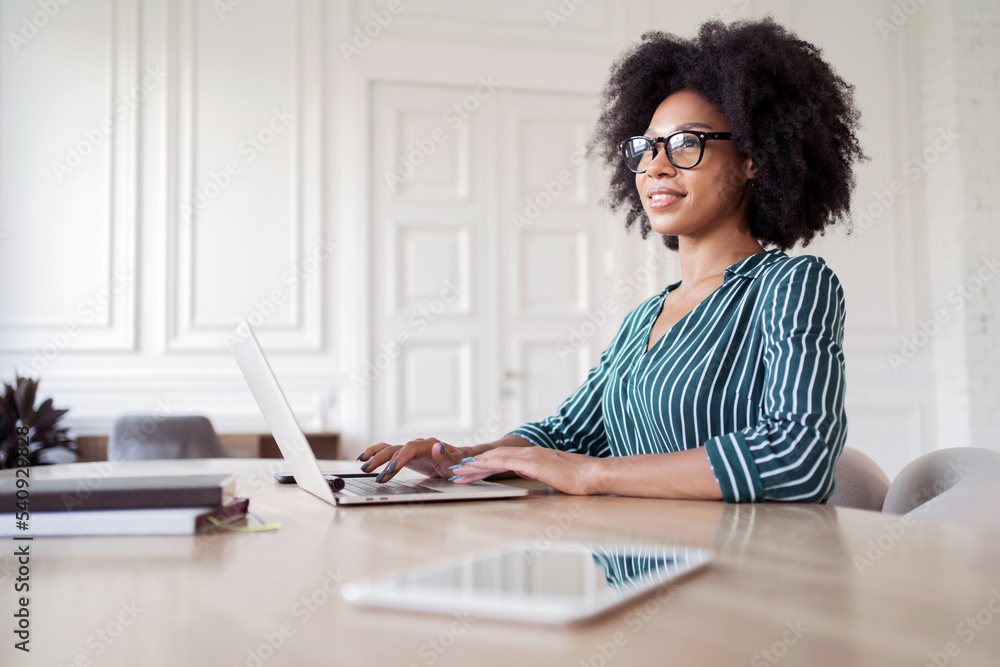 Workplace in the office a female administrator makes a report using a laptop computer. Routine work in the office.