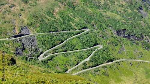 Winding mountain roads leading to Vikafjellet mountain crossing Norway - Summer static handheld clip from nearby peak looking down at road rv13 carved into mountainside photo