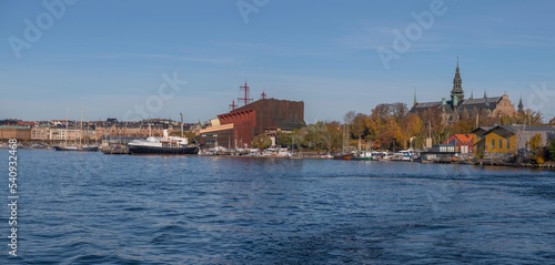 Museum building and boats at the pier Galärvarvet a colorful autumn day in Stockholm