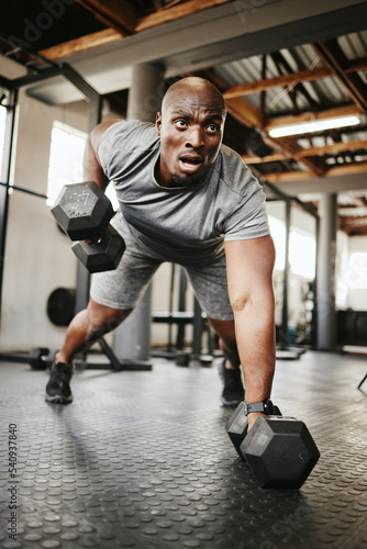 Fitness, gym and black man doing a workout with weights for strength, wellness and training. Bodybuilder, sports and strong African athlete doing push up exercise in a sport, health and active studio