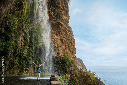 Cascata dos Anjos - woman standing under Angels waterfall in Madeira