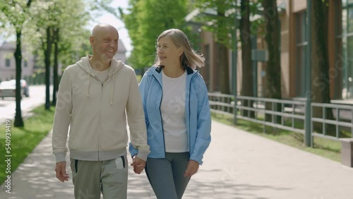 Wallpaper Mural Mature couple holding hands while walking together in the street. Rear view of romantic senior family resting after jogging. People, sport, love and communication concept Torontodigital.ca