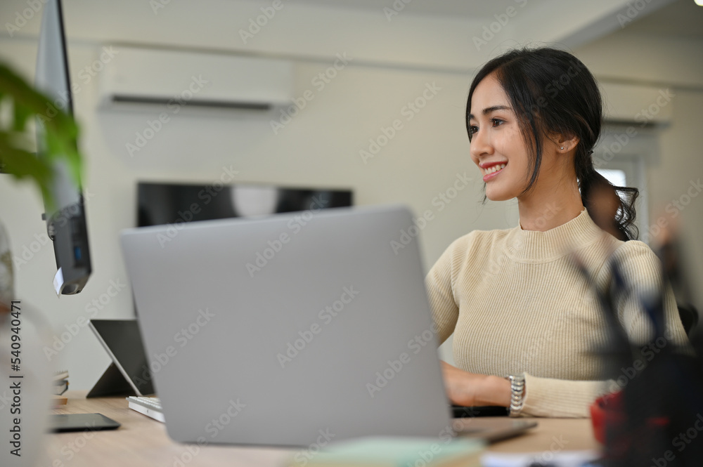 Charming Asian female marketing employee or businesswoman working in the office.