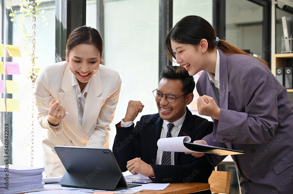 Overjoyed millennial Asian businesspeople celebrating project success, project winning Overjoyed millennial Asian businesspeople celebrating project success, project winning
