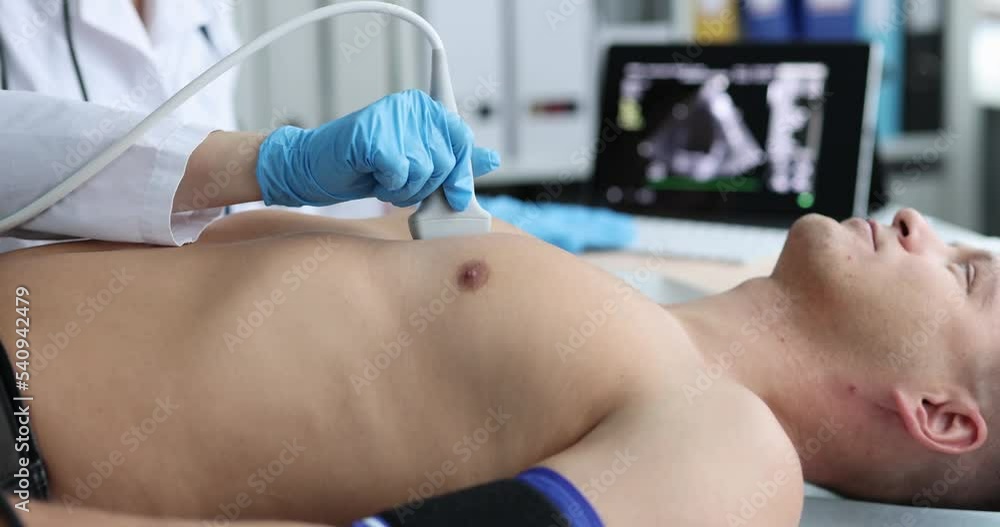Doctor places ultrasound probe on chest of male patient Doctor places ultrasound probe on chest of male patient
