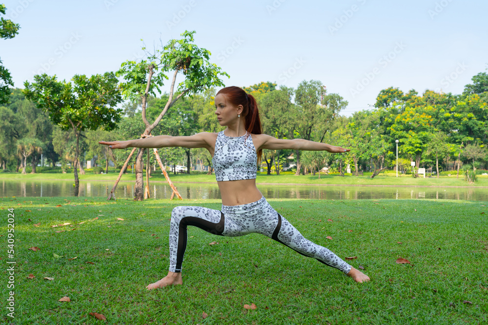 Portrait photo of a young beautiful brunette woman lady with fit body build practicing high skill yoga poses for her daily fitness exercise training in a community park Portrait photo of a young beautiful brunette woman lady with fit body build practicing high skill yoga poses for her daily fitness exercise training in a community park