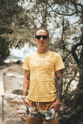 Blonde man with pony tail standing on the beach