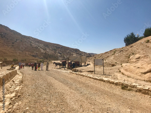 Petra, Jordan, November 2019 - A group of people walking down a dirt road