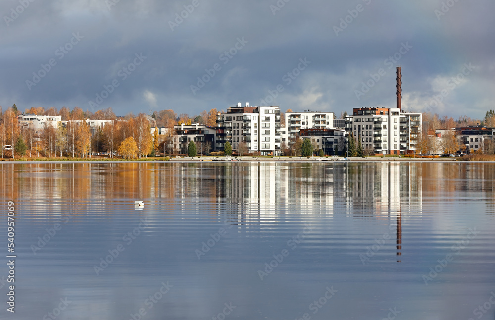 Fototapeta premium Steel blue clouds over a city and a tranquil lake