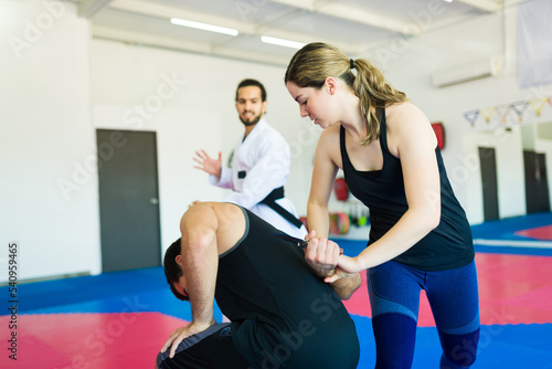 Fotografía Strong woman fighting an attacker at martial arts school