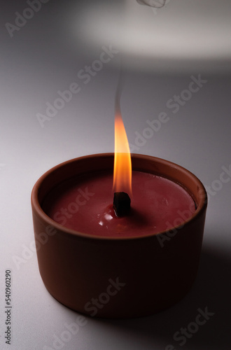 A burning candle isolated on a dark background. A candle with a flame in the dark close-up. A flame symbolizing the memory of the dead.