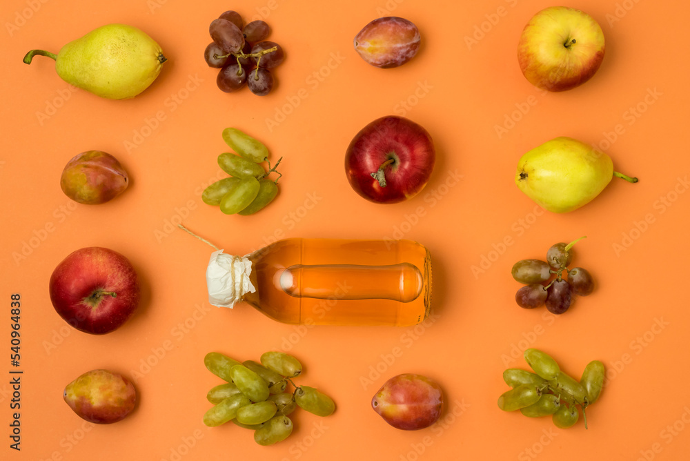 Bottle With Apple Cider or Vinegar with Raw Autumn Fruits Grape Apples Pears Plums on Orange Background Top View Horizontal Bottle With Apple Cider or Vinegar with Raw Autumn Fruits Grape Apples Pears Plums on Orange Background Top View Horizontal