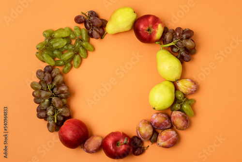 Fruits Apple Plums Pears on Orange Background in Shape of Wreath Top View Horizontal