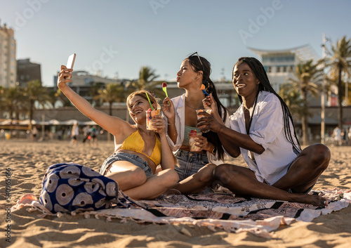 Woman having fun at sunset on tropical beach and taking selfie © PintoArt