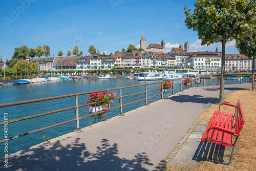 beautiful lakeside promenade with bench, tourist resort Rapperswil, view to harbor and castle photo