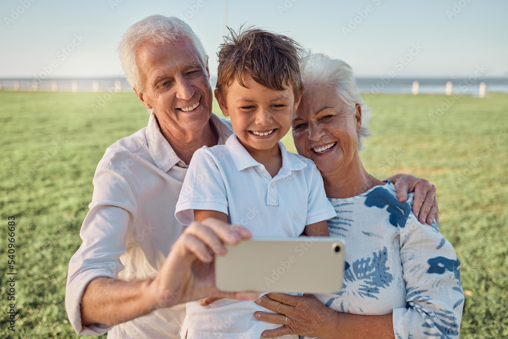 Kid, grandparents and phone selfie on grass in park spending time together on the weekend. Grandma, grandpa and boy child with smile on face, happy family take outdoor portrait on smartphone on field Kid, grandparents and phone selfie on grass in park spending time together on the weekend. Grandma, grandpa and boy child with smile on face, happy family take outdoor portrait on smartphone on field