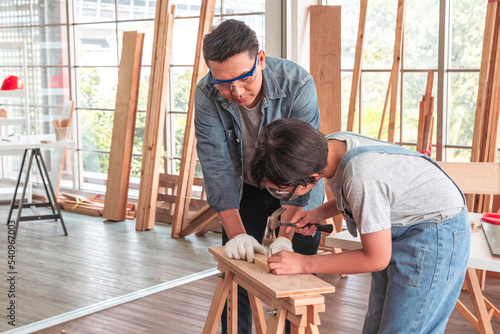 Attentive carpenter is teaching his son.