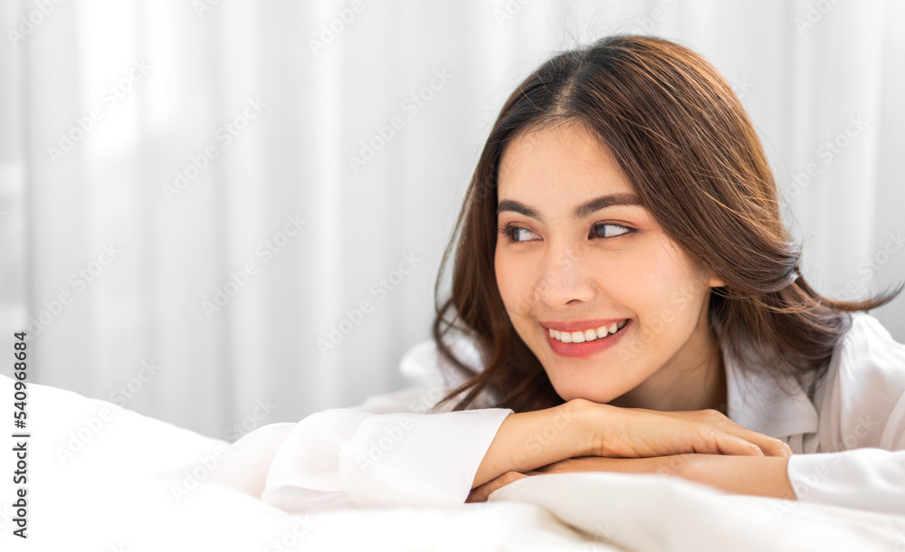 Portrait of smiling cheerful beautiful pretty asian woman clean fresh healthy white skin posing smile in pajamas white clothes.Girl felling relax and enjoy time on the bed at home.asia beauty Portrait of smiling cheerful beautiful pretty asian woman clean fresh healthy white skin posing smile in pajamas white clothes.Girl felling relax and enjoy time on the bed at home.asia beauty