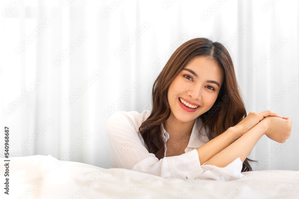 Portrait of smiling cheerful beautiful pretty asian woman clean fresh healthy white skin posing smile in pajamas white clothes.Girl felling relax and enjoy time on the bed at home.asia beauty Portrait of smiling cheerful beautiful pretty asian woman clean fresh healthy white skin posing smile in pajamas white clothes.Girl felling relax and enjoy time on the bed at home.asia beauty