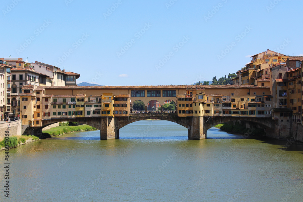 Ponte Vecchio crowded with tourists on a sunny afternoon, horizontal.