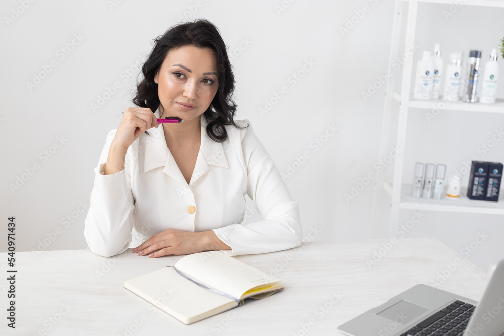 Indian woman beautician takes notes in office - cosmetologist business woman or doctor concept Indian woman beautician takes notes in office - cosmetologist business woman or doctor concept