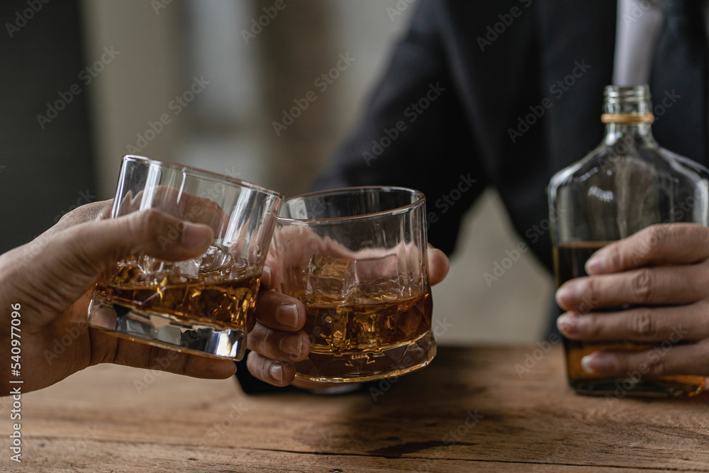 Close-up of serious businessman holding whiskey glass shows concept of executive privilege. Soft focus. Close-up view of two men in formal wear whiskey clashing glasses.
Close-up of serious businessman holding whiskey glass shows concept of executive privilege. Soft focus. Close-up view of two men in formal wear whiskey clashing glasses.