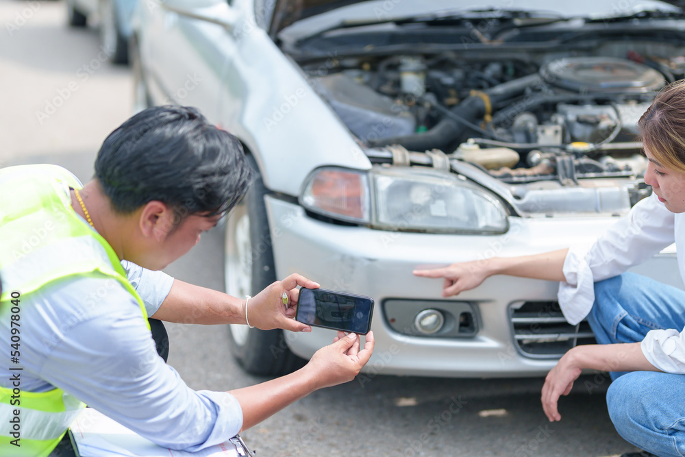 Insurance agent takes pictures of crashed car on his smartphone and fills out the insurance. Insurance agent services concept Insurance agent takes pictures of crashed car on his smartphone and fills out the insurance. Insurance agent services concept