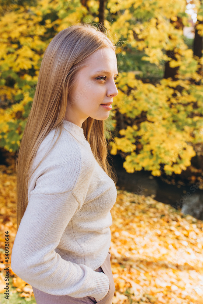 Close up blondie woman outdoor portrait in autumn park. Happy caucasian girl with long natural blondie hair Close up blondie woman outdoor portrait in autumn park. Happy caucasian girl with long natural blondie hair