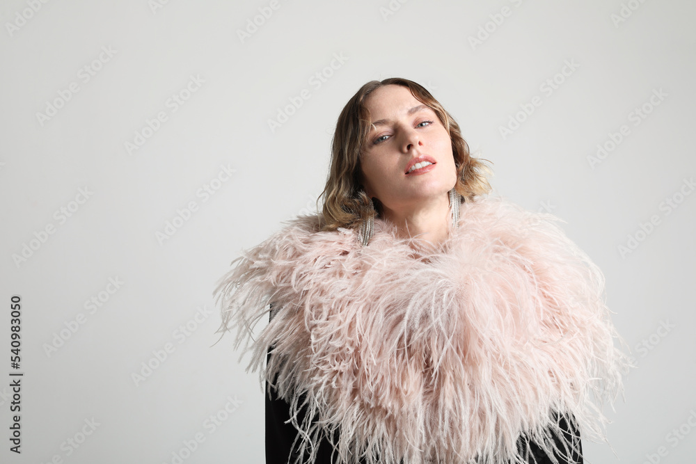 Amazing luxury elegant woman in stylish party dress posing before white wall. Amazing luxury elegant woman in stylish party dress posing before white wall.
