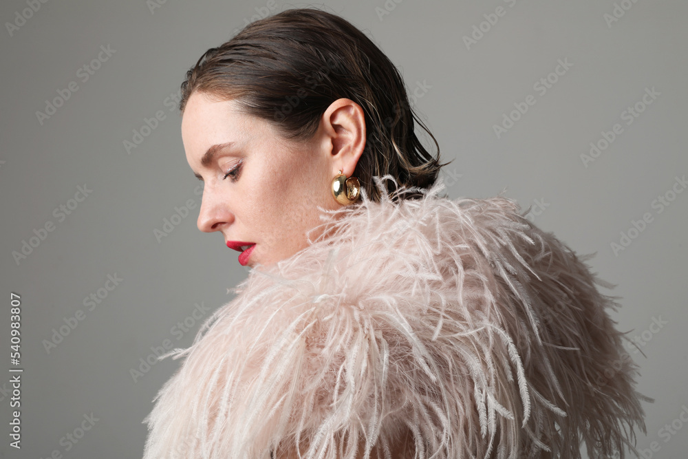 Elegant woman in stylish feathers dress. Beautiful sensual female with makeup Elegant woman in stylish feathers dress. Beautiful sensual female with makeup