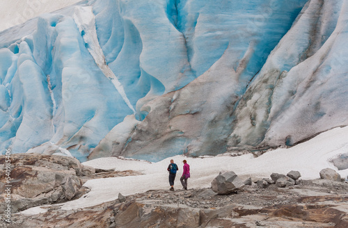 A man and a woman hiking at the Fabergstolsbreen glacier, the arm of  the Jostedalsbreen glacier, the biggest glacier in continental Europe, located in Sogn og Fjordane county, Norway. photo