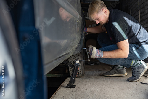 Mechanic replaces a wheel on a car