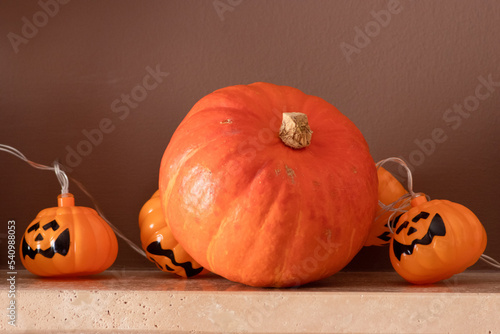 Electric halloween lights and an orange colour pumpkin decor on a fireplace background  photo